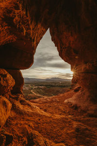 Sunset over st. george as seen from inside a red rock cave entrance