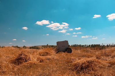 Hay bales on field against sky