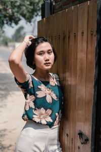 Portrait of teenage girl standing by gate