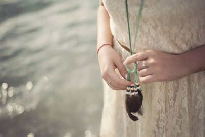 Midsection of woman wearing dreamcatcher