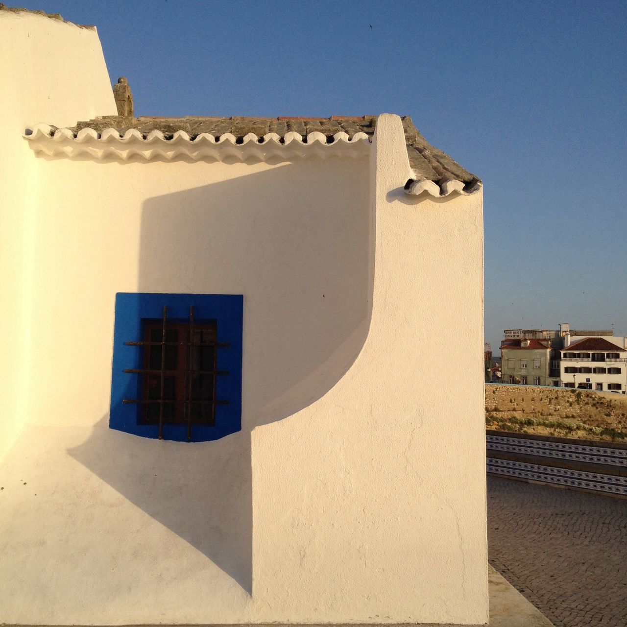 architecture, building exterior, built structure, clear sky, window, low angle view, house, sunlight, residential structure, building, residential building, history, day, copy space, wall - building feature, no people, shadow, facade, outdoors, blue