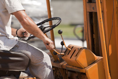 Midsection of man driving tractor