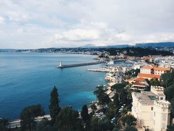 High angle view of townscape by sea against sky