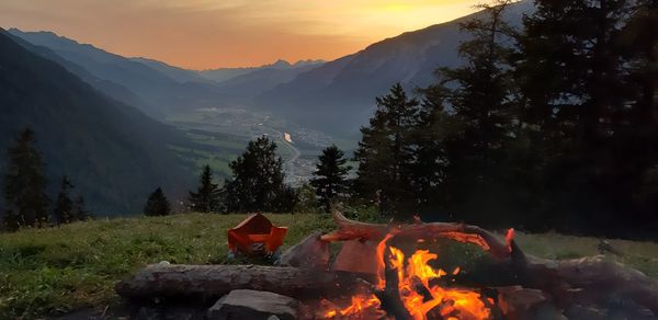 Bonfire on field against orange sky