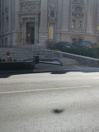 Empty road by buildings in city