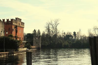 Scenic view of lake by buildings against sky