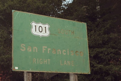 Close-up of information sign against trees