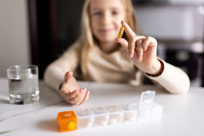 Portrait of cute girl showing medicine