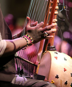 Midsection of man playing musical instrument