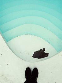 Low section of man standing at poolside