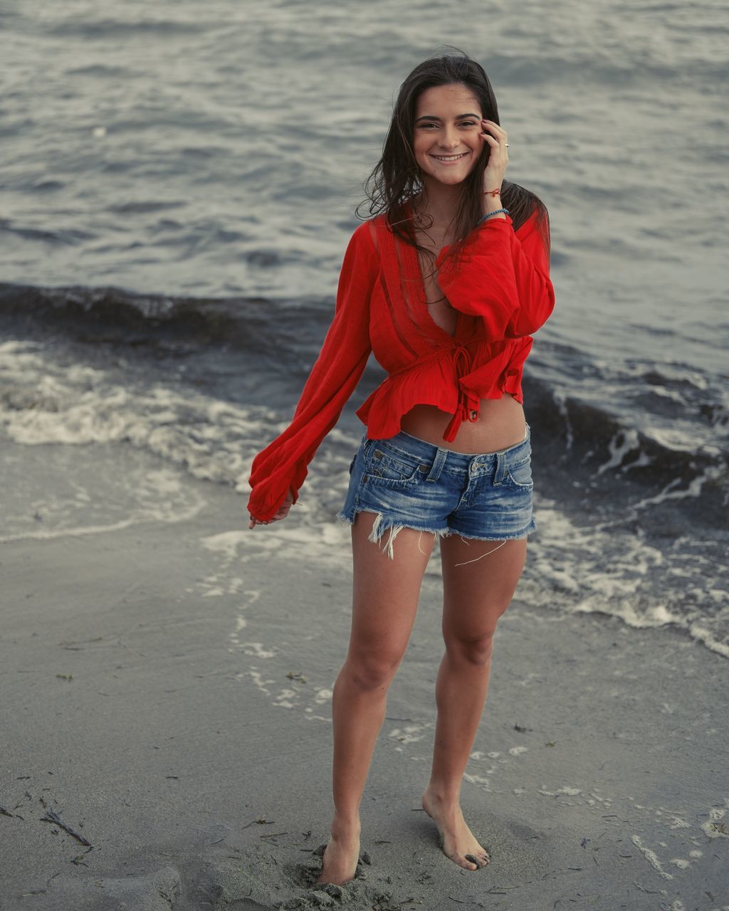 one person, beach, real people, leisure activity, land, water, young women, young adult, full length, standing, lifestyles, sea, looking at camera, casual clothing, beautiful woman, portrait, smiling, women, hair, hairstyle, outdoors