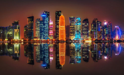 Illuminated buildings against sky at night