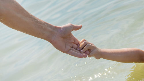 Midsection of man holding water in sea