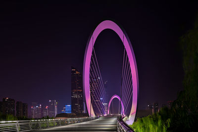 Illuminated bridge against sky at night