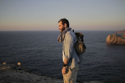 Side view of man standing against sea