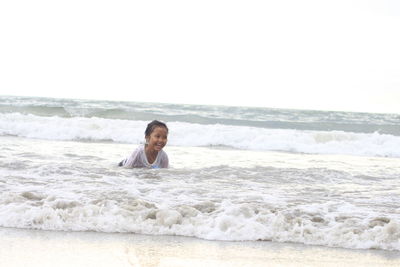 Rear view of woman sitting on beach