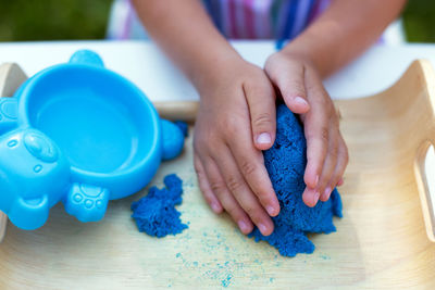 Close-up of hands on blue table