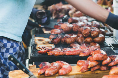 Close-up of man preparing food on barbecue grill