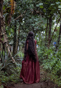 Rear view of woman standing in forest