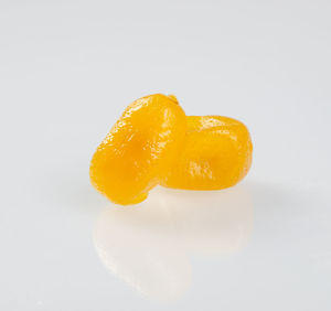 Close-up of orange slice over white background