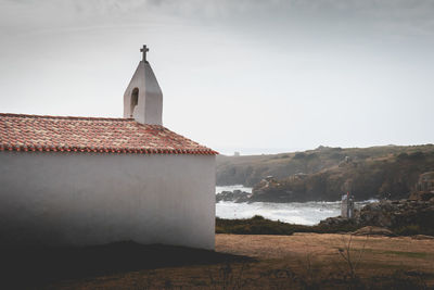 Building by sea against sky