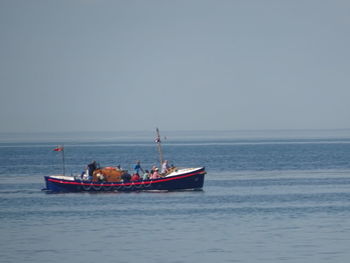 Fishing boat in sea against clear sky