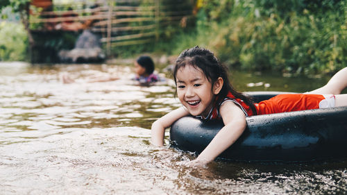 Happy girl relaxing on inflatable ring floating in lake