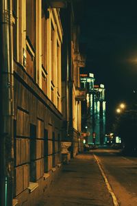 Narrow street amidst buildings in city at night