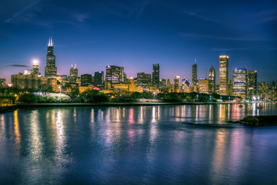 Illuminated buildings in city against sky