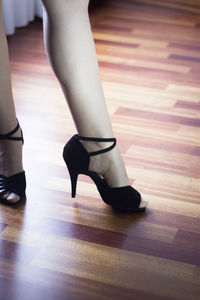 Low section of woman standing on hardwood floor