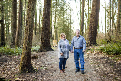 Elderly couple holding hands in the forest.