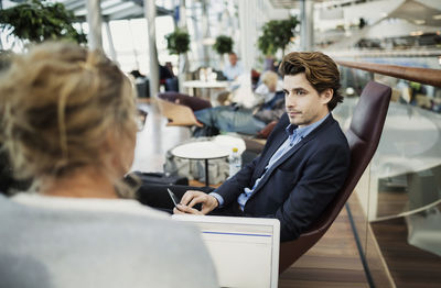 Businesspeople using technologies at lobby in airport