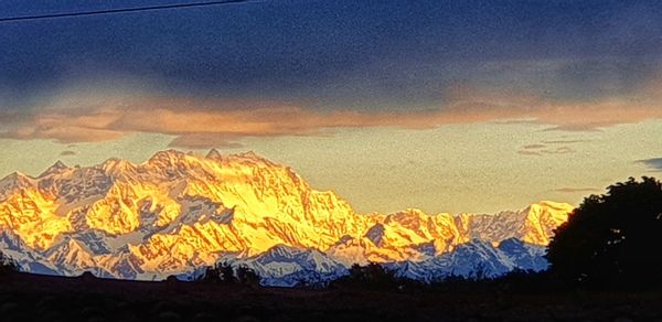 Scenic view of snowcapped mountains against sky during sunset