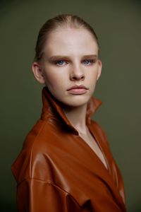 Portrait of young woman against black background