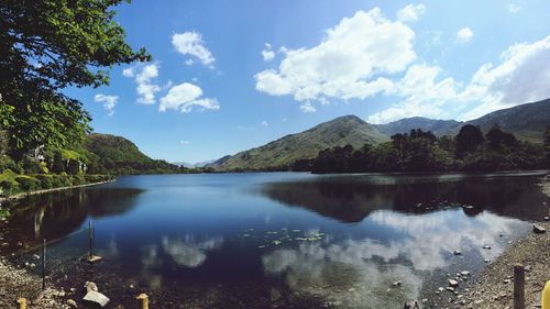 Scenic view of lake by mountains against sky