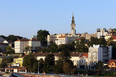 Buildings in city against clear sky