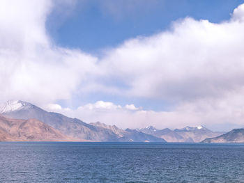 Scenic view of sea and mountains against sky