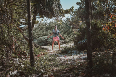 Man with arms raised in forest