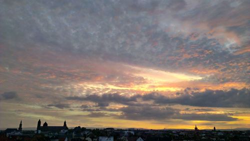 View of cityscape against cloudy sky during sunset