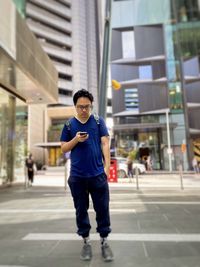 Portrait of young man walking on street in city