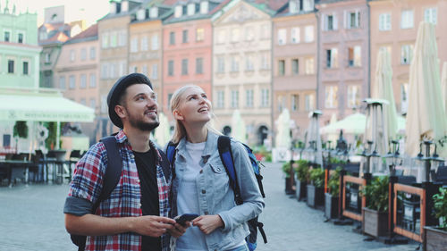 Full length of a young woman using phone in city
