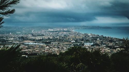 View of cityscape against cloudy sky