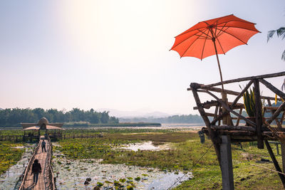 The wooden hut with long wooden bridge among the lotus flower fields at ban nam thong village.