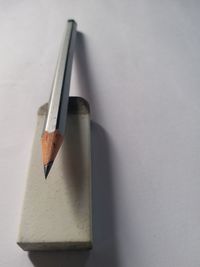 High angle view of pencil on table against white wall