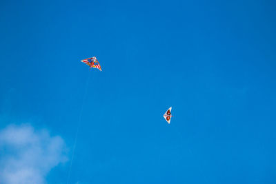 Low angle view of kites flying in sky