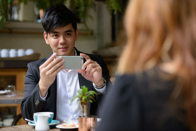 Couple holding mobile phone outdoors