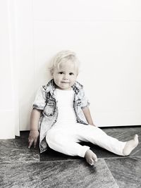 Portrait of cute smiling girl sitting on floor