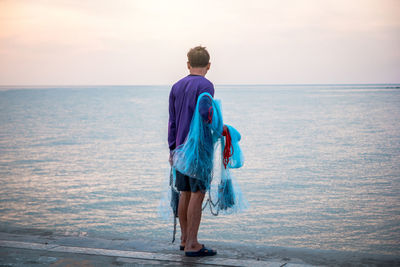 Rear view of woman looking at sea against sky