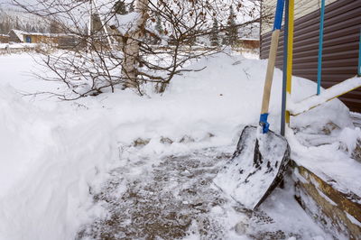 Shovel for clearing snow from the track, standing at the porch.