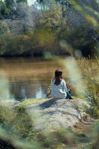 Woman sitting alone near a lake